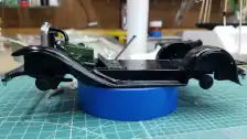 Left side view of Fender-Frame Floor pan, radiator, radiator hose, front suspension, luggage carrier, rear bumper and shifter installed